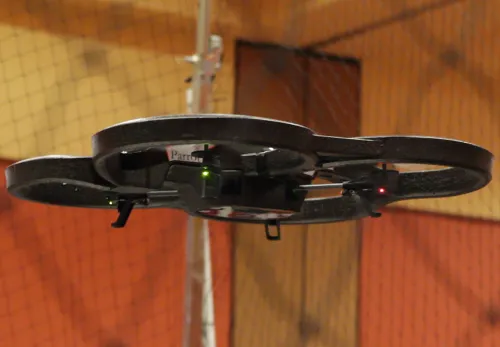 A large drone flying inside a safety net